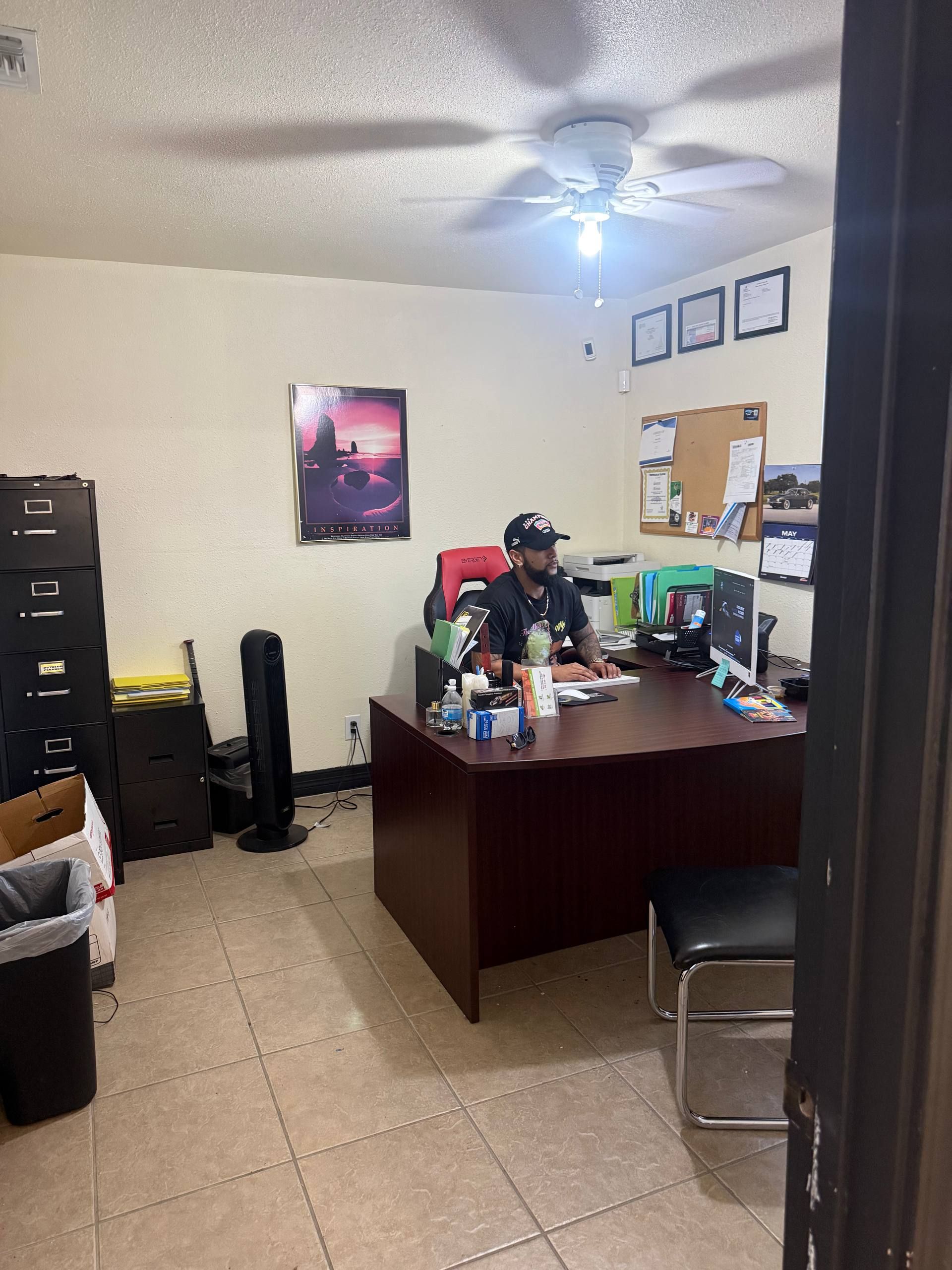 A salesperson at the desk inside Aleman Auto Sales.